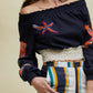 linen top in blue with coral embroideries hand made worn with striped pants in blue orange beige turquoise by atelier ferdinando fusco